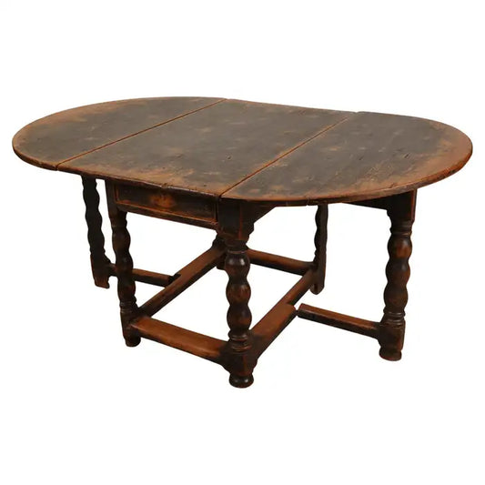 A sturdy Baroque gateleg table, ideal as a dining table, made in Sweden in the mid-18th century. The leaves are semi-circular. The legs feature beautifully turned forms and are connected by sturdy crossbars. The table has two pull-out drawers, one on each side. White background.