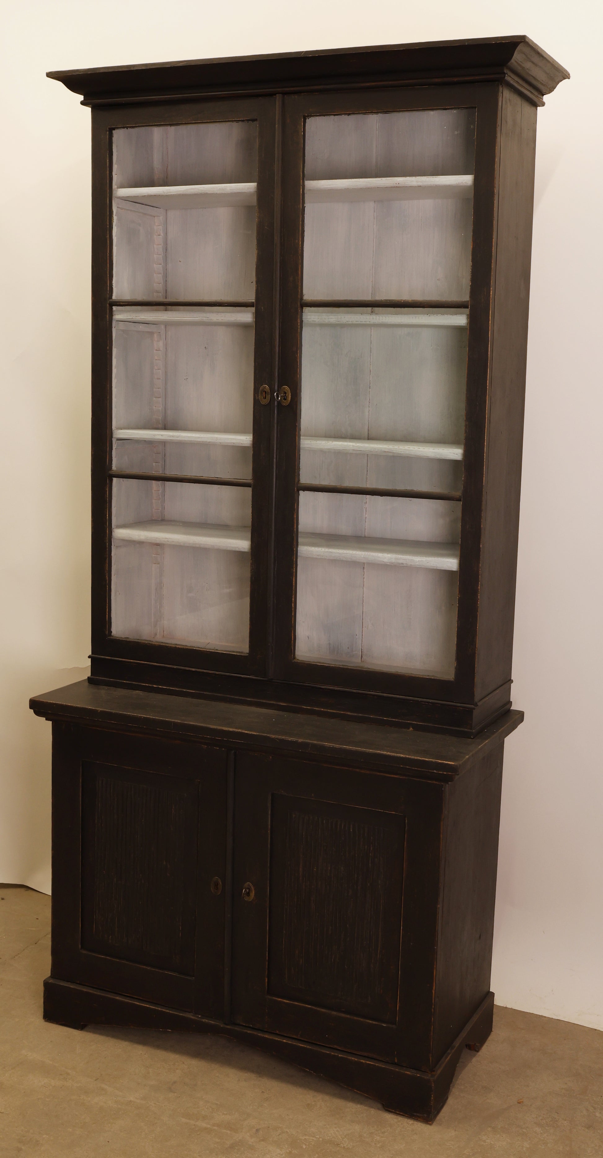 A black Gustavian cabinet.
