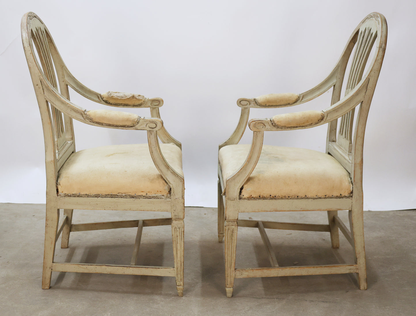 Side view of a pair of antique Gustavian armchairs.