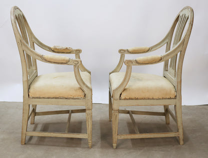 Side view of a pair of antique Gustavian armchairs.