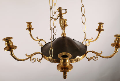 High-class Empire pendant from Stockholm around 1800-1810. It features six beautifully decorated candle arms with acanthus leaves. The central decoration includes a female figure standing on a sphere. Three chains support the pendant, which culminates at the top with a plate before the ceiling hook. The ring is adorned with Medusa heads. The pendant is finished at the bottom with a decoration of a pine cone in fire-gilded bronze.