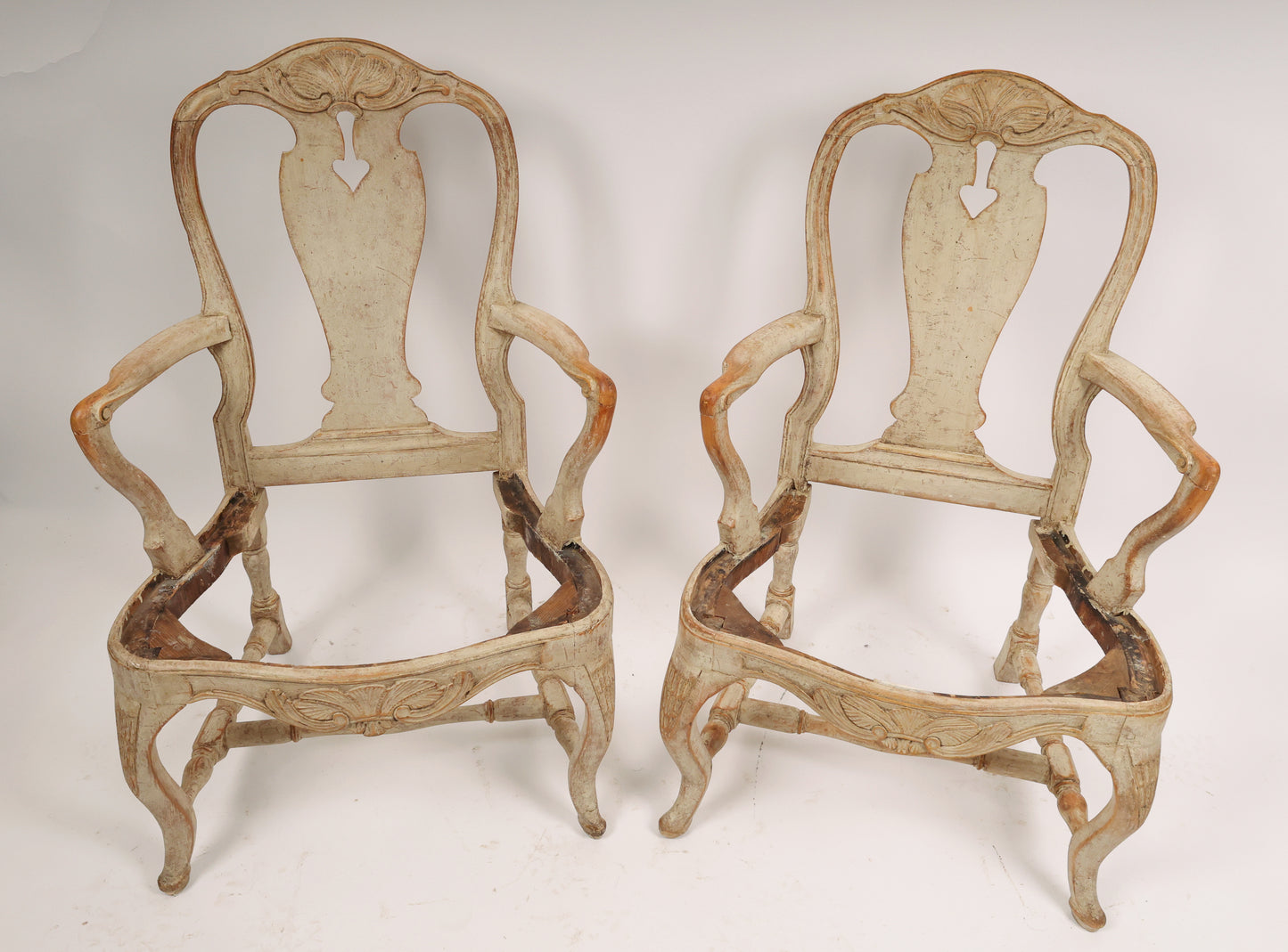 A pair of Rococo armchairs made in Stockholm around 1760/70. Featuring carvings of rocailles with pickering in both the apron and the back. The chairs are equipped with H-stretchers and have removable upholstered seats.