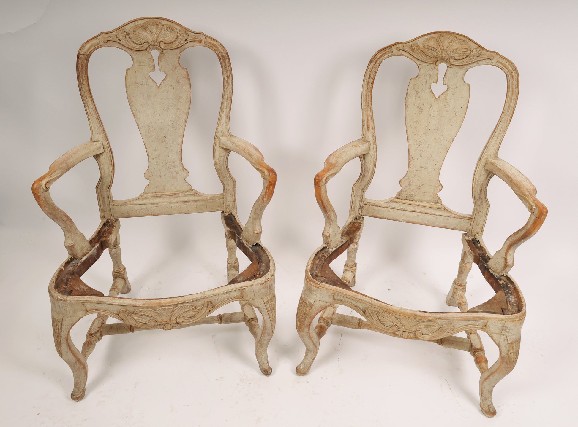 A pair of Rococo armchairs made in Stockholm around 1760/70. Featuring carvings of rocailles with pickering in both the apron and the back. The chairs are equipped with H-stretchers and have removable upholstered seats.