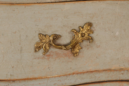 Gilded details on a Rococo chest of drawers.
